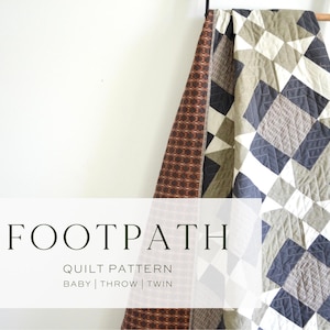 May include: A quilt with a geometric pattern in shades of gray, white, and navy blue, draped over a black ladder. The quilt features the text "FOOTPATH" and "QUILT PATTERN" with size options: BABY | THROW | TWIN.