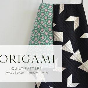 Puede incluir: Un edredón plegado con un estampado floral en un lado y un diseño geométrico en el otro. El edredón es negro con formas geométricas blancas y grises. El texto "ORIGAMI QUILT PATTERN" es visible.