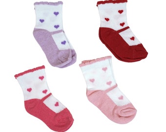 Könnte beinhalten: Vier Paar Socken mit weißem Hintergrund und Herzen in verschiedenen Farben. Die Socken sind rosa, rot, lila und hellrosa.