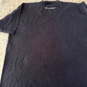 Puede incluir: Camiseta negra con el texto "Natural Anthem." impreso en la espalda.