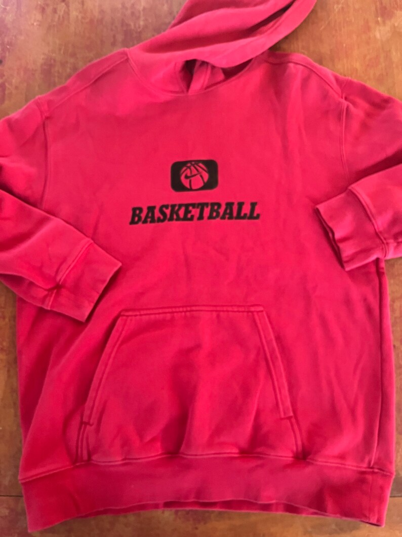 May include: Red hooded sweatshirt with a black basketball graphic and the word "BASKETBALL" printed on the front.
