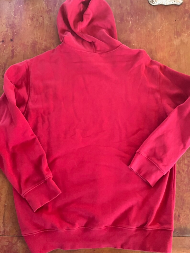 May include: A red hooded sweatshirt with a pouch pocket.