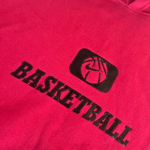 May include: Red hooded sweatshirt with a black basketball graphic and the word "BASKETBALL" in black lettering.