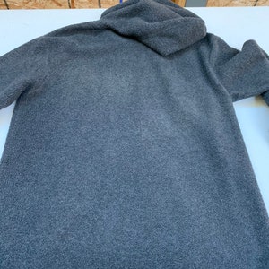May include: A dark gray hooded fleece sweatshirt with a soft, fuzzy texture.