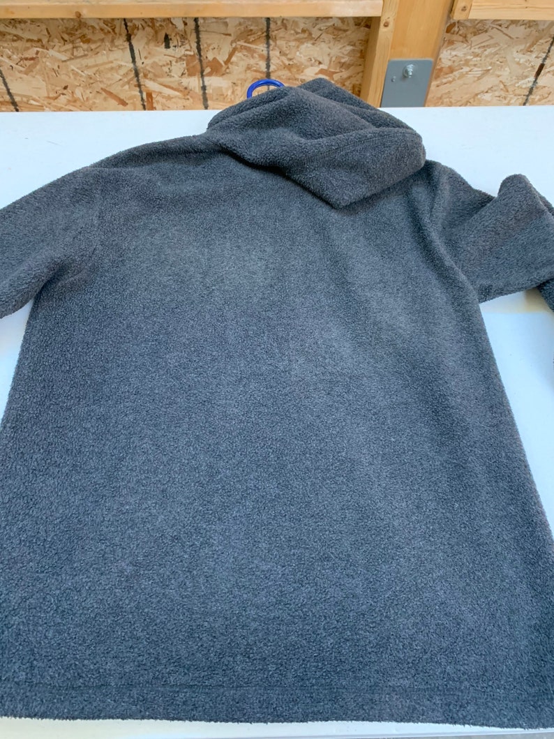 May include: A dark gray hooded fleece sweatshirt with a soft, fuzzy texture.