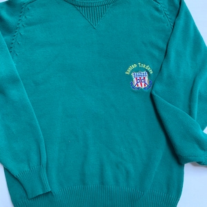 May include: A teal green sweater with a navy blue, red, and white embroidered logo that says "Boston Traders" with an anchor and a shield.