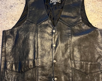 May include: Black leather vest with a snap closure and two front pockets. The vest has a label that reads "First Genuine Leather" with a star logo.