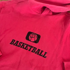 May include: Red hooded sweatshirt with a black basketball graphic and the word "BASKETBALL" printed in black.