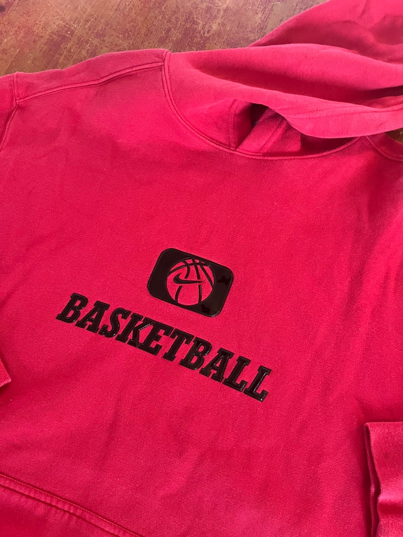 May include: Red hooded sweatshirt with a black basketball graphic and the word "BASKETBALL" printed in black.