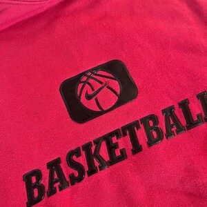 May include: A red hoodie with a black basketball graphic and the word "BASKETBALL" in black lettering.