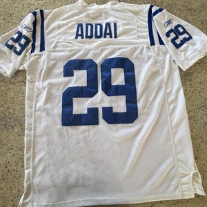 May include: White mesh football jersey with blue accents and the name "ADDAI" across the shoulders. The number "29" is displayed in blue on the sleeves and back. A Reebok logo is visible on the sleeve.