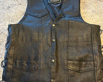 May include: Black leather vest with a lace-up detail on the sides. The vest has a  "BARNEY'S LEATHER" label with a bull's head logo.