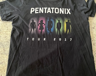 Può includere: Maglietta nera Pentatonix Tour 2017. La maglietta presenta il nome della band in lettere bianche sopra sagome colorate dei membri della band. La parola "TOUR" e l'anno "2017" sono stampati sotto.