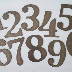 May include: Set of ten metal numbers, painted in a brown color, from 1 to 0. The numbers are cut out and have a rustic, vintage look.