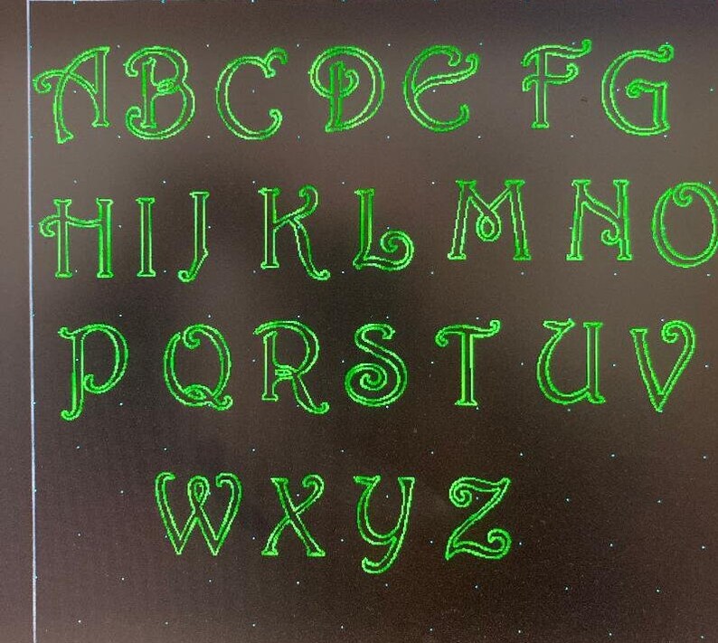 May include: A green alphabet with decorative lettering on a black background.
