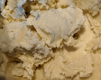 May include: Close-up of a scoop of vanilla ice cream. The ice cream has a light beige color with a slightly textured surface. The image shows the creamy, soft texture of the dessert.