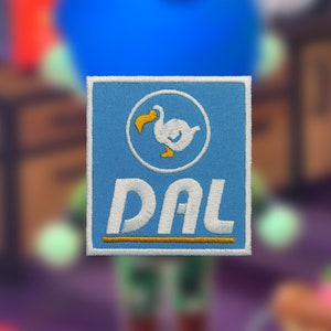 May include: A blue and white embroidered patch with a white dodo bird inside a circle and the text "DAL" below the circle.