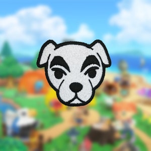 以下が含まれることがあります： 黒い目と鼻の周りに黒いマークが付いた白い犬の顔が刺繍されたパッチ。パッチは黒い縁取りがあり、ビデオゲームファン向けである可能性があります。背景は、ビーチシーンのぼやけた画像です。