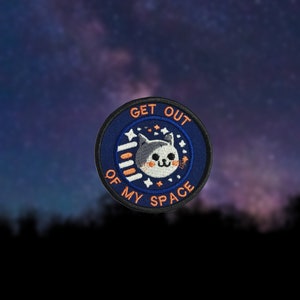 May include: A blue and white embroidered patch with a cat face and the text "Get Out Of My Space".