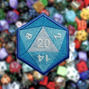 May include: A blue 20-sided die with white numbers, a popular item for tabletop role-playing games. The die is embroidered with a blue and white design.