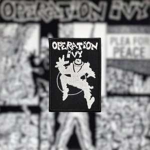Peut inclure: Patch brodé noir et blanc avec le texte "OPERATION IVY" et une silhouette blanche d'une personne sautant en l'air.