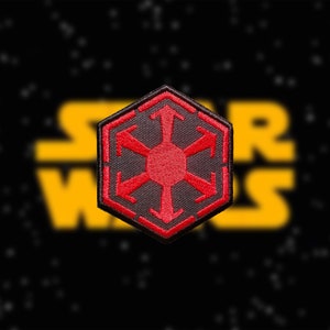 Może przedstawiać: Naszywka haftowana w kolorze czerwonym i czarnym przedstawiająca symbol Galaktycznego Imperium z Gwiezdnych Wojen. Symbol to sześciokąt z czerwonym, przypominającym płatek śniegu wzorem w środku.