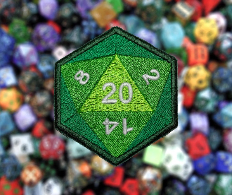 May include: Green twenty-sided die with white numbers, 1, 4, 7, 8, 12, 20, embroidered on a green fabric patch.