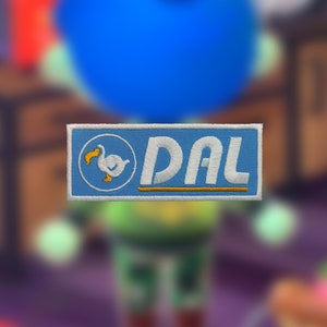 May include: A blue and white embroidered patch with a white dodo bird and the text "DAL" in white letters on a blue background.