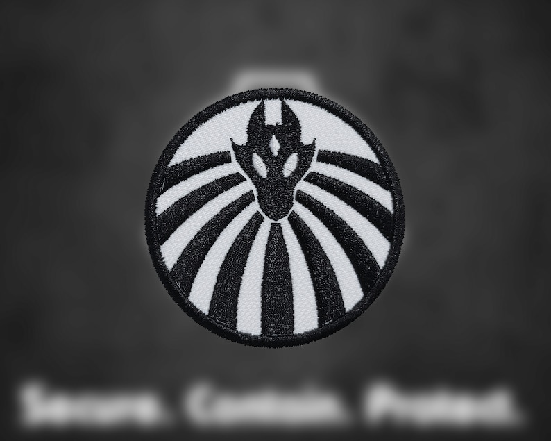 May include: Black and white embroidered patch with a stylized dragon design. The dragon is facing forward with its wings spread out. The patch is circular and has a white background with black lines radiating out from the center.