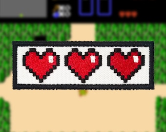 Könnte beinhalten: Ein weißer Patch mit drei roten, pixelartigen Herzen, umgeben von einem schwarzen Rand. Der Patch ist ein gängiger Gesundheitsindikator in Videospielen.