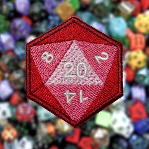May include: A red and pink embroidered patch shaped like a twenty-sided die with the numbers 1, 4, 8, 12, 16, and 20 visible.