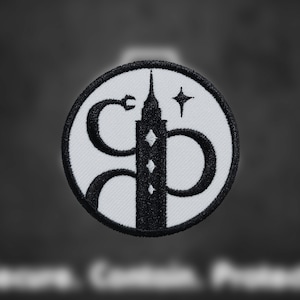 May include: Black and white embroidered patch featuring a stylized building with a star above it. The building is surrounded by a snake-like design.