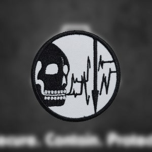May include: Black and white embroidered patch with a skull and a heartbeat line. The skull is facing left and the heartbeat line is on the right side of the patch.