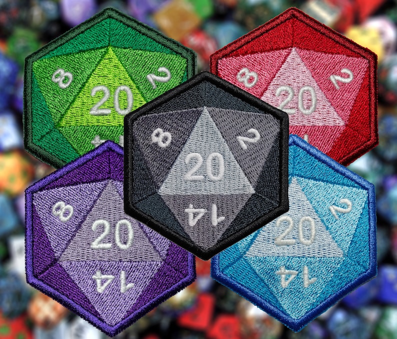 May include: Five 20-sided dice, each with a different color: green, red, black, purple, and blue. The dice are embroidered with white numbers and are arranged in a stack.