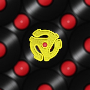 May include: A yellow vinyl record adapter, also known as a 45 adapter, is centered against a background of black vinyl records with red labels.