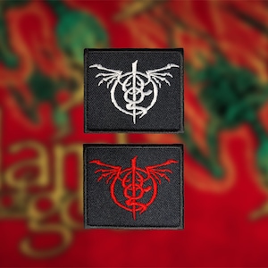 Peut inclure: Deux écussons carrés noirs avec des motifs brodés. L'un présente un emblème blanc avec un serpent ailé, l'autre une version rouge du même emblème. Le fond est un motif rouge et or flou.