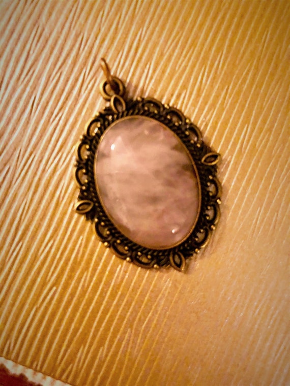 Rose Quartz Cabochon Pendant surrounded in a Brass Setting.