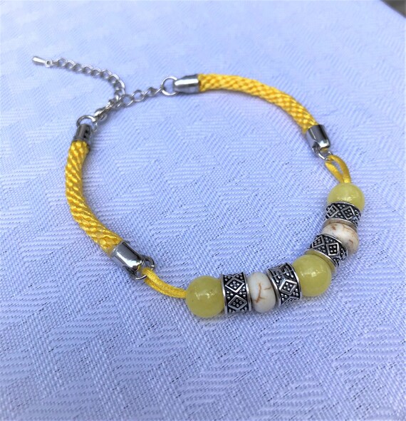 Satin Hand Braided Bracelet accented with Yellow Icy Jade, Howlite and Silver Plated Beads.