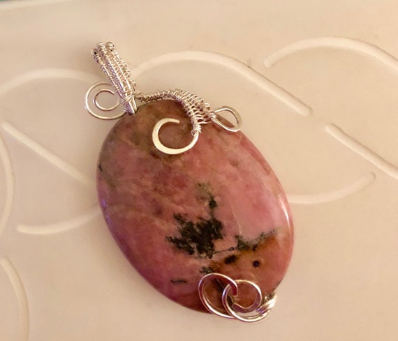 Rhodonite bead is encased in a Sterling Silver wire weave.