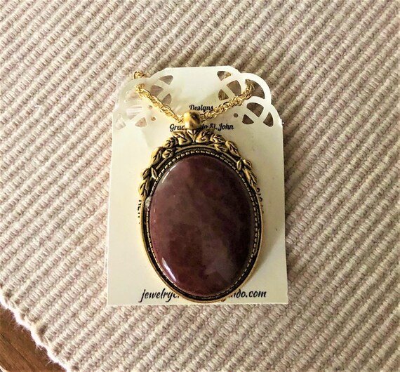 This Red Jasper Cabochon is set in a Brass Setting (gold) and comes with a 14K Gold Plated Chain.