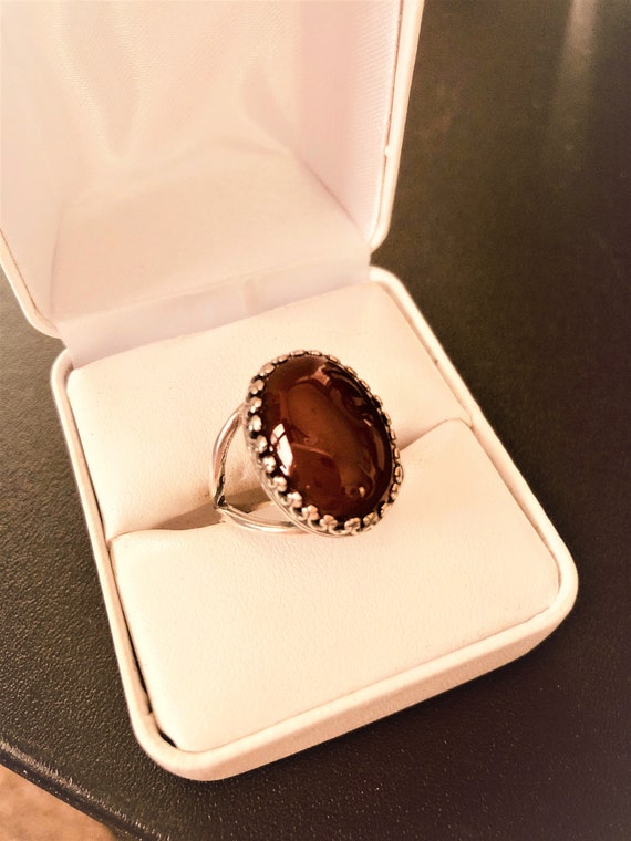 This Carnelian adjustable ring is set in a Silver-plated crown bezel.