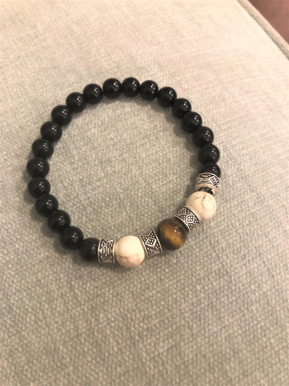 This mysterious and powerful Tiger Eye stretch bracelet is surrounded with Howlite, Black Jasper and Silver Plated Spacer Beads.