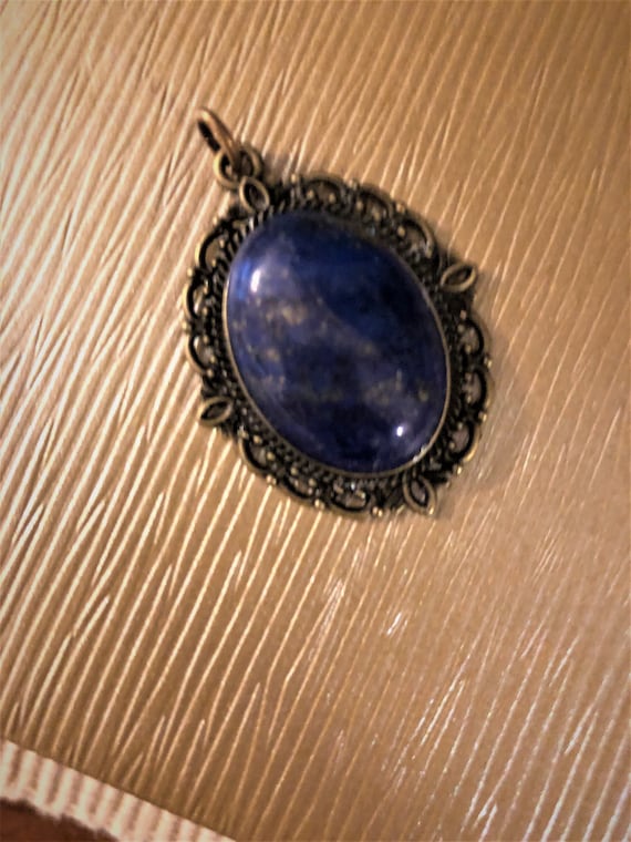 Ghost Eye Jasper Cabochon Pendant surrounded by a brass setting.
