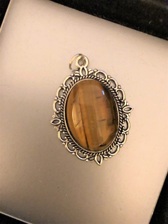 Tiger Eye Cabochon surrounded by a Silver Plated Setting.