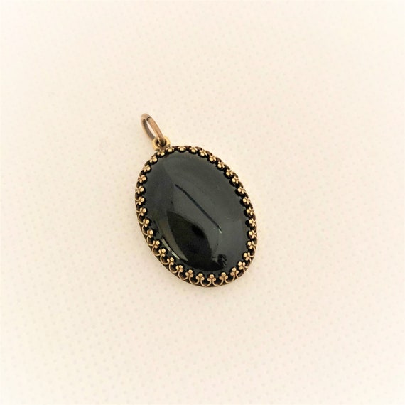 This Black Onyx Cabochon is set in a brass setting and includes an oxidized copper chain.