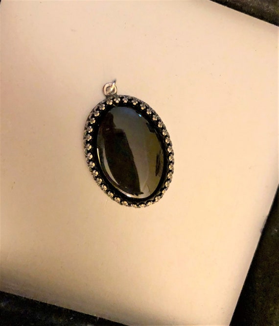 Black Onyx Cabochon encased in a Silver Plated Setting.