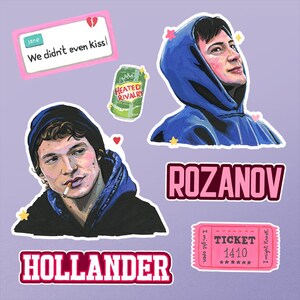 以下が含まれることがあります： パーカーを着た2人のイラスト、Heated Rivalryと書かれた緑色のソーダ缶、We didn't even kissと書かれたピンクのテキストボックス、1410と書かれたピンクのチケット、そして太字のピンク色でROZANOVとHOLLANDERと書かれた名前が並ぶステッカーシート。