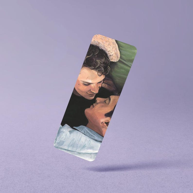 May include: A rectangular bookmark featuring a painted illustration of two individuals lying close together. One individual has dark curly hair and is looking down, while the other is looking up. They are positioned against a green and black background.