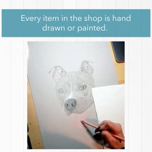 Op de afbeelding: Potloodtekening van een hondengezicht, in grijstinten en wit. De tekst "Every item in the shop is hand drawn or painted" staat bovenaan. Een hand gebruikt een roze potlood om kleur aan het kunstwerk toe te voegen.