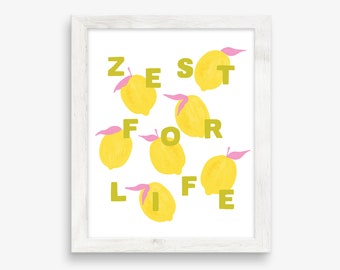 May include: A framed art print with a white wooden frame. The print features yellow lemons with pink leaves arranged around the words "ZEST FOR LIFE" in green letters on a white background. The artwork has a cheerful, summery vibe.